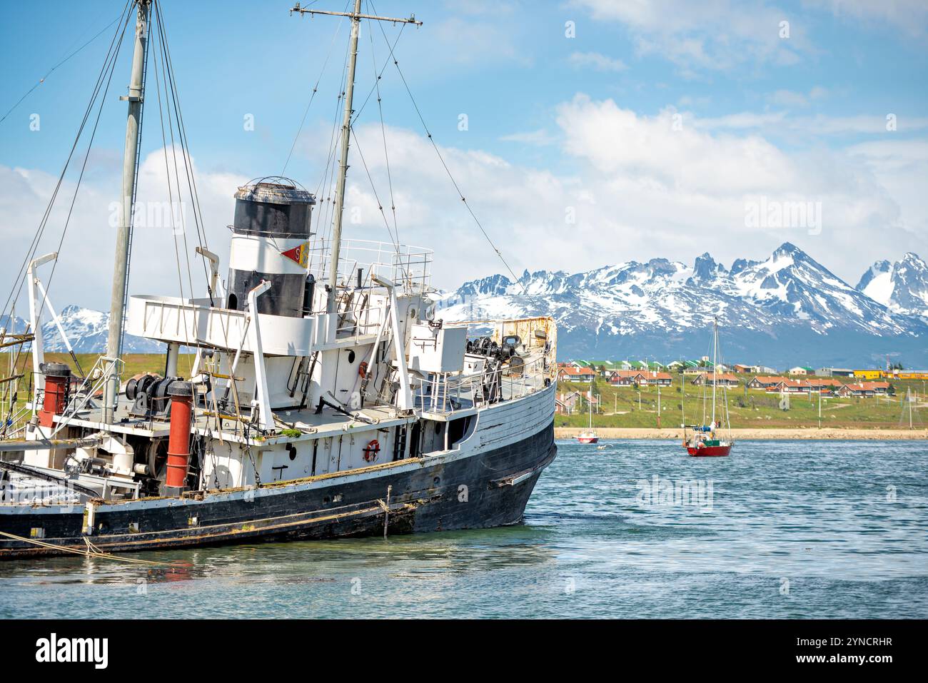 USHUAIA, Argentinien – der Heilige Christoph (ehemals HMS Justice) liegt am Strand im Hafen von Ushuaia vor einem Hintergrund schneebedeckter Berge. Der Rettungsschlepper aus der Zeit des Zweiten Weltkriegs wurde 1957 absichtlich an Bord genommen, nachdem er bei Bergungseinsätzen Motorprobleme hatte. Das Schiff dient heute als Denkmal für die maritime Geschichte der Beagle-Channel-Region. Stockfoto