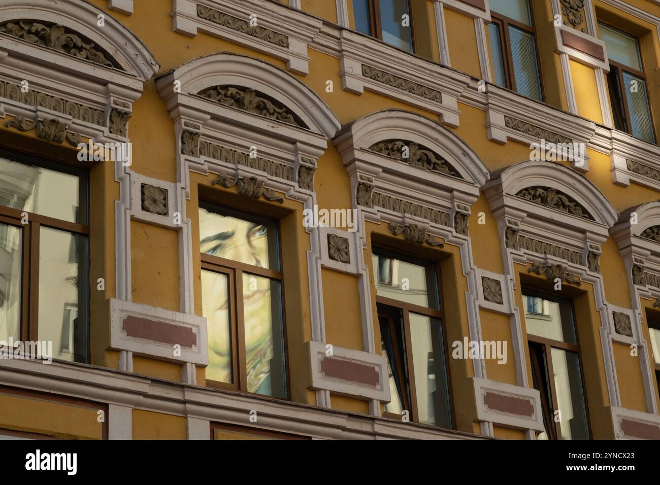 Moskau, Russland - 15. August 2024: Die Reflexion der Graffiti-Kunst von Marschall Schukow, die durch die Fenster eines historischen Gebäudes in Moskau einfängt wird, Showcasin Stockfoto