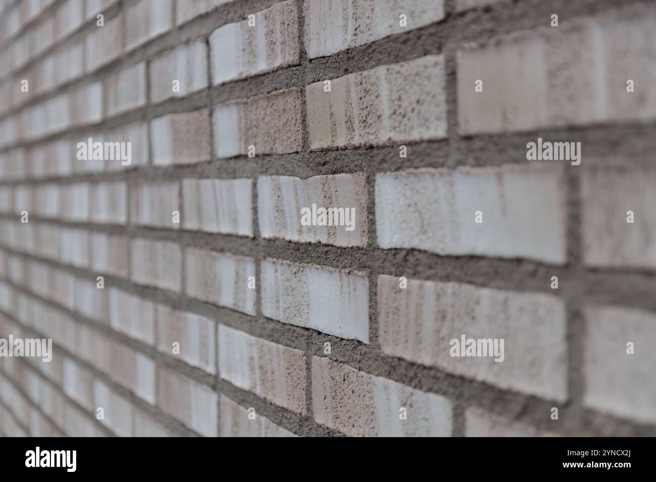 Beige und graue Backsteinwand Hintergrund Nahaufnahme. Grauer Steinfliesenblockhintergrund mit horizontaler Textur des grauen Ziegels. Graue Ziegeloberfläche Stockfoto