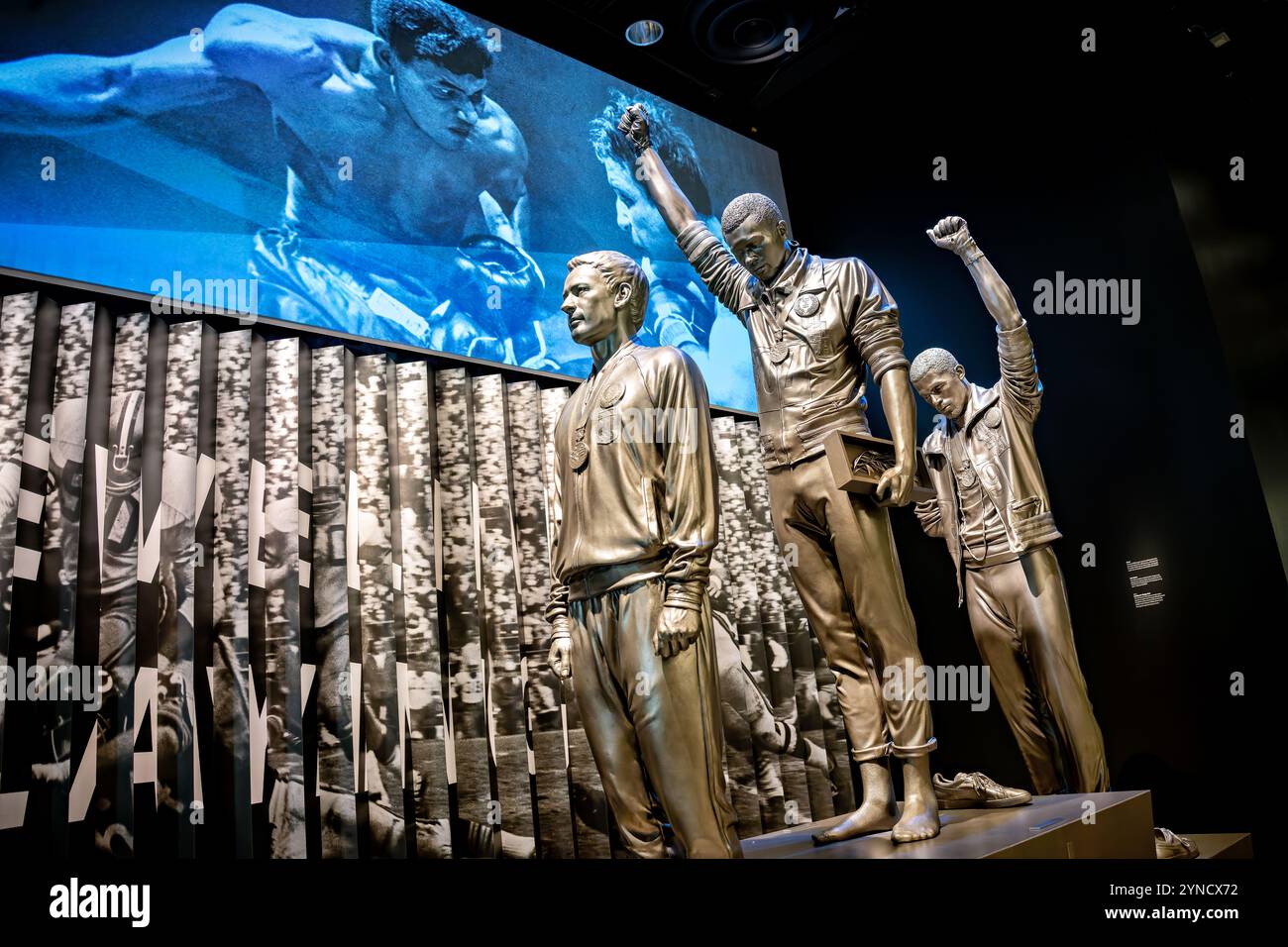 1968 Olympische Proteststatue NMAAHC Washington DC // WASHINGTON DC – Statuen stellen den legendären Olympischen Protest von Tommie Smith und John Carlos aus dem Jahr 1968 im National Museum of African American History and Culture nach. Die Ausstellung in The Sports: Levelling the Playing Field Gallery erinnert an ihren Black Power-Gruß während der Medaillenzeremonie bei den Olympischen Spielen in Mexiko-Stadt, an der Seite des australischen Silbermedaillen Peter Norman. Stockfoto