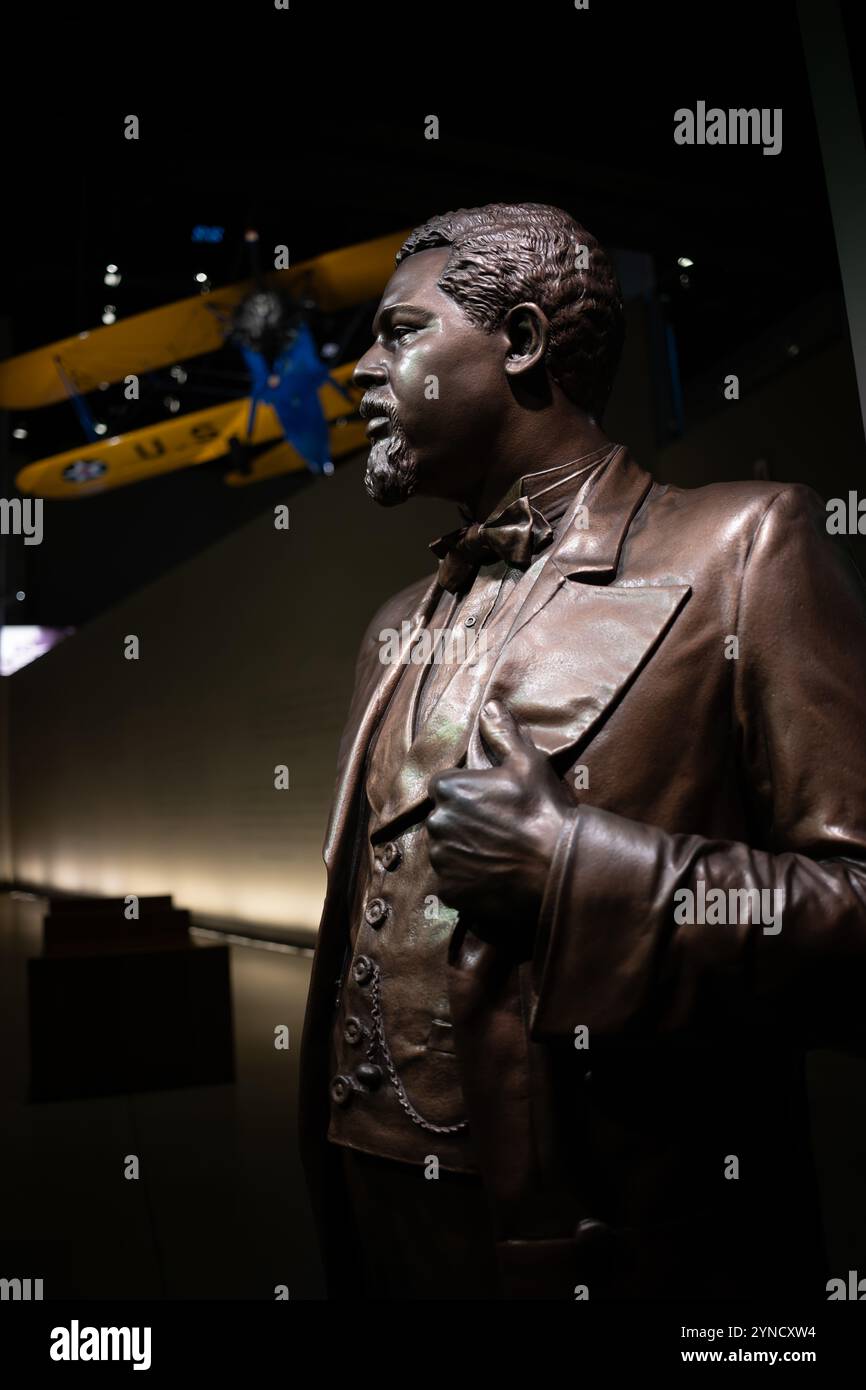 Robert Smalls Statue Tuskegee Airmen Flugzeug Washington DC // WASHINGTON DC — das National Museum of African American History and Culture zeigt eine Bronzestatue von Robert Smalls, dem versklavten Piloten, der ein Schiff der Konföderierten in die Freiheit kommandierte und später als US-Kongressabgeordneter diente. Über der Statue hängt ein restauriertes PT-13D Stearman Kaydet Trainingsflugzeug, das von den Tuskegee Airmen, Amerikas ersten schwarzen Militärpiloten, eingesetzt wurde. Das Flugzeug, das von Captain Matt Quy restauriert wurde, trägt Unterschriften von Original Tuskegee Airmen auf seiner unteren Tür. Stockfoto