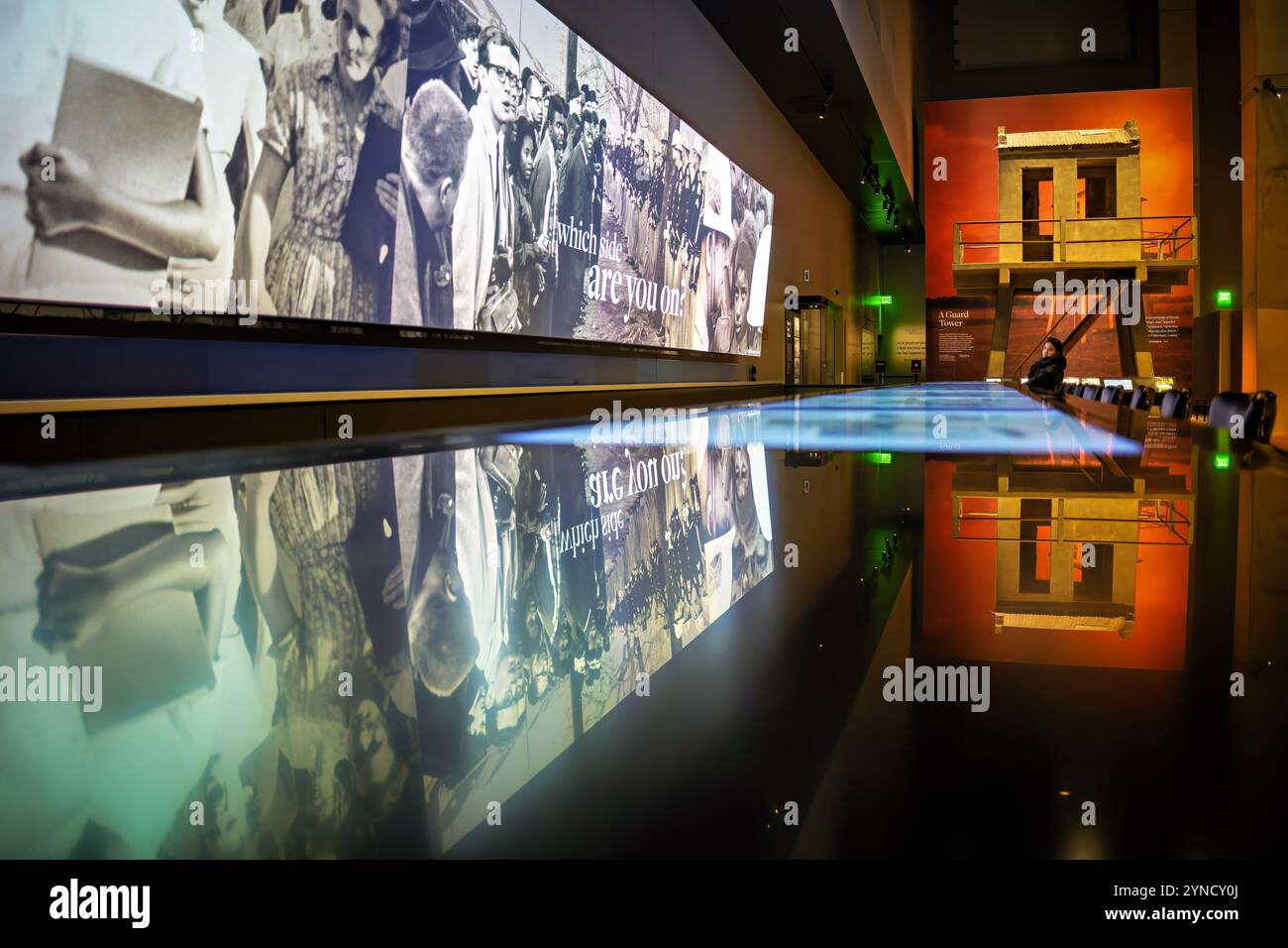 National Museum of African American History Lunch Counter Exhibit Washington DC | WASHINGTON D.C., Vereinigte Staaten – Ein Besucher sitzt vor einer spiegelnden Lunch-Theke, die die 1960 Greensboro Sit-ins im National Museum of African American History and Culture nachbilden, unter einem Wandbild mit der Aufschrift „Wo Side are you?“ (auf welcher Seite bist du?) Ein nachgebildeter Wachturm des Angola-Gefängnisses steht dahinter, ein Teil der Galerien für Bürgerrechte und Segregation des Museums. Stockfoto