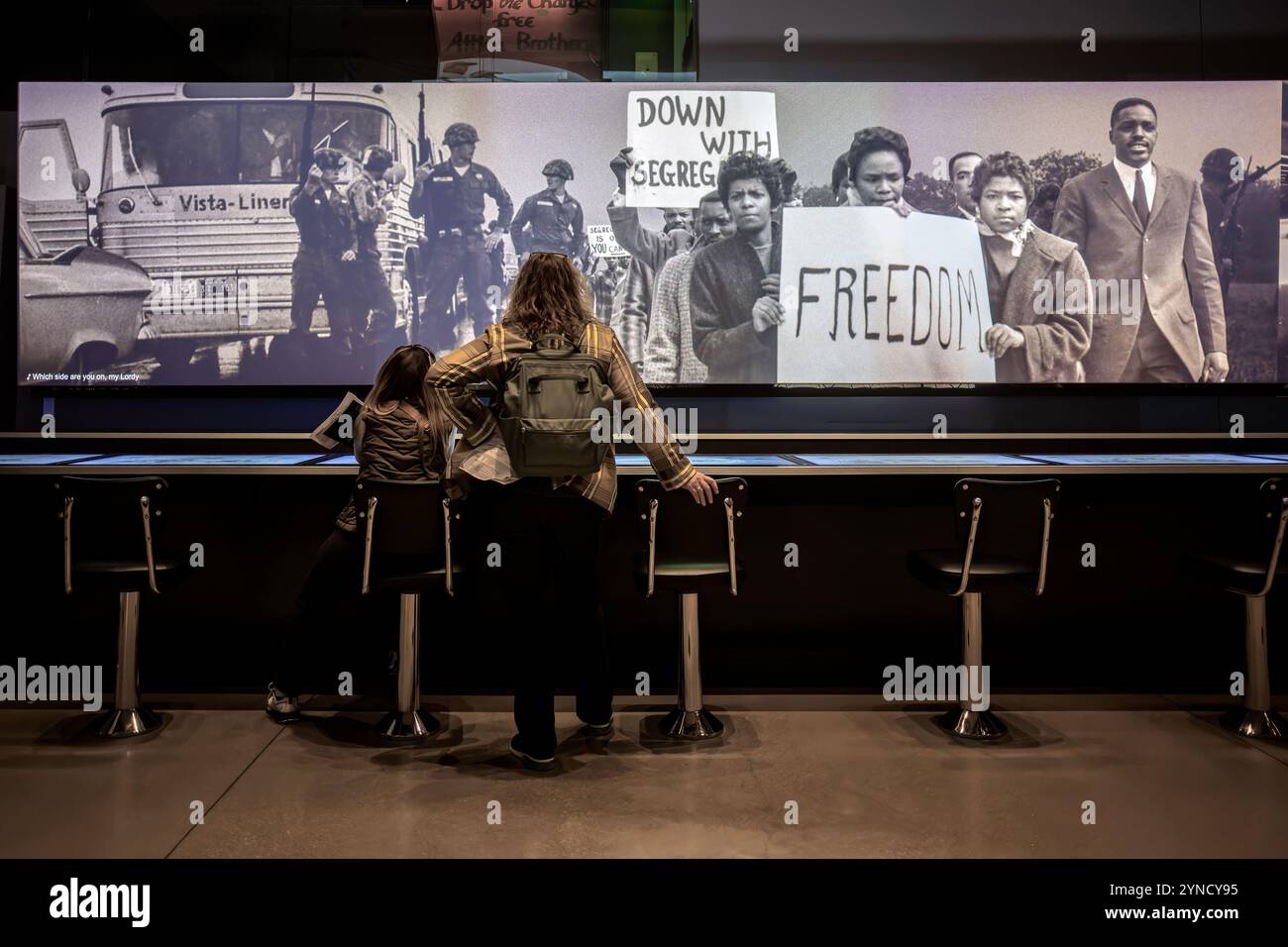 National Museum of African American History Lunch Counter Exhibit Washington DC | WASHINGTON D.C., Vereinigte Staaten – Besucher sitzen an einer neu gestalteten Lunch Counter Exponate im National Museum of African American History and Culture, einer interaktiven Hommage an die Greensboro-Sit-ins von 1960. Vier Black College-Studenten inszenierten den ursprünglichen Protest an einem separaten Woolworth's Lunch Counter in Greensboro, North Carolina, um die breitere Sit-in-Bewegung gegen die Jim Crow-Segregation anzuzünden. Stockfoto