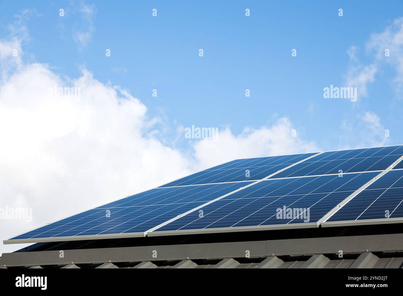Luftaufnahme von Solarzellen vor bewölktem blauen Himmel. Konzept der alternativen Energie, nachhaltige Ressourcen. Haus mit Solarpaneelen, eigenständiges Foto Stockfoto