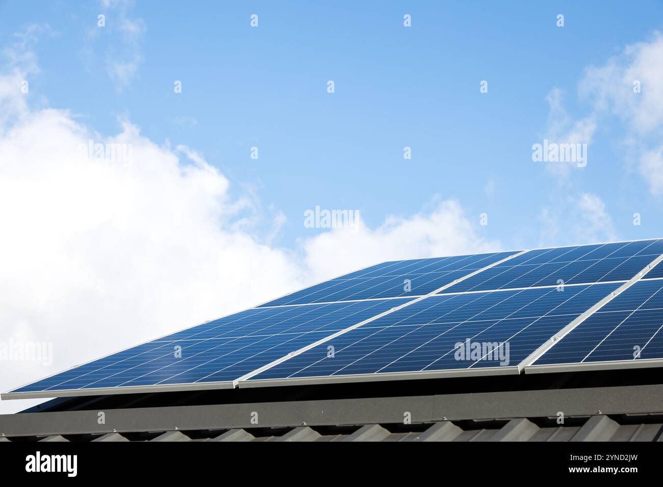 Luftaufnahme von Solarzellen vor bewölktem blauen Himmel. Konzept der alternativen Energie, nachhaltige Ressourcen. Haus mit Solarpaneelen, eigenständiges Foto Stockfoto