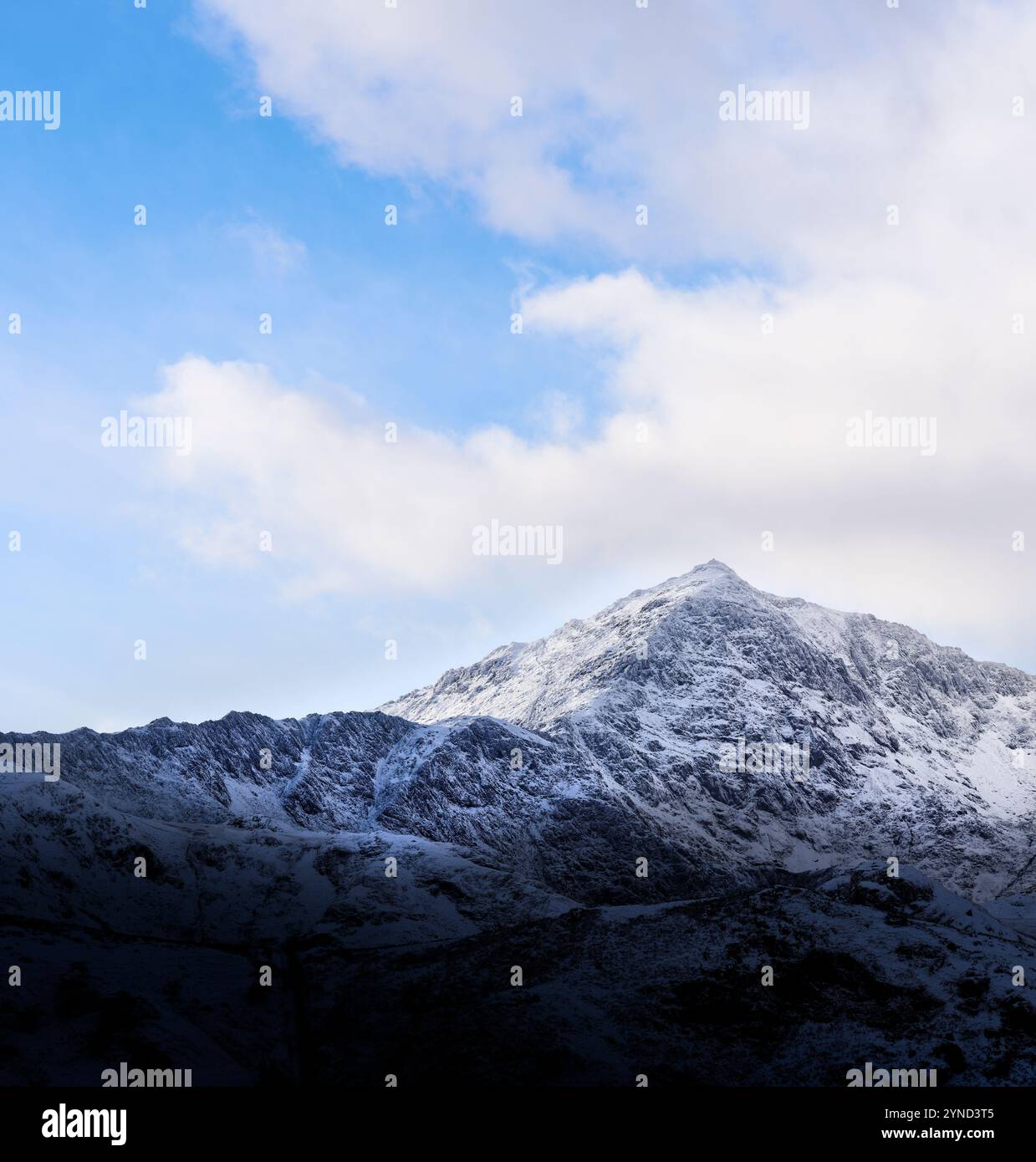 Gipfel des Mount Snowdon (Yr Wyddfa), Snowdonia (Eryri), Wales, bedeckt mit Schnee an einem bewölkten Wintertag mit etwas blauem Himmel. Stockfoto