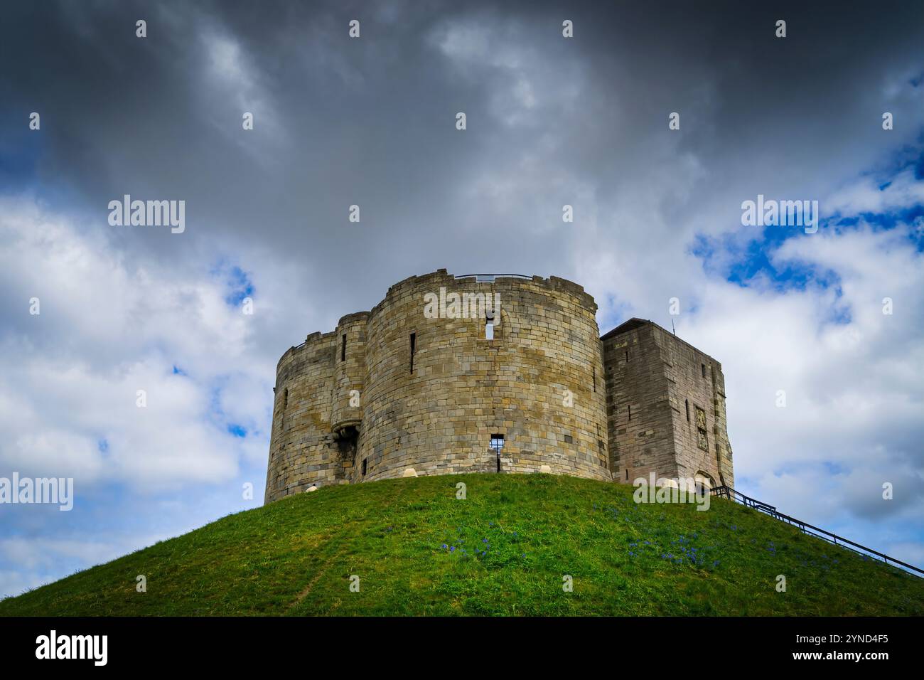 Alten Clifford Tower in der Dämmerung auf einem grünen Hügel und blauer Himmel im Hintergrund mit dunklen Wolken. York in Großbritannien. Stockfoto Alten Clifford Tower in der Dämmerung auf einem grünen Hügel und blauer Himmel im Hintergrund mit dunklen Wolken. York in Großbritannien. Stockfoto