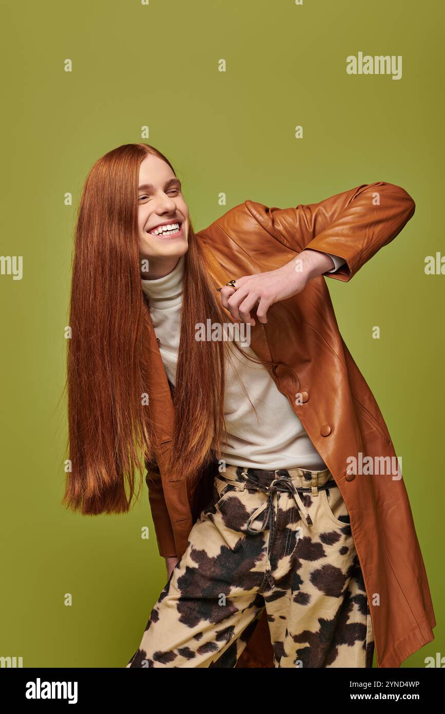 Emotionaler junger Mann mit langen roten Haaren genießt einen Moment des Glücks in einer lebendigen Umgebung Stockfoto