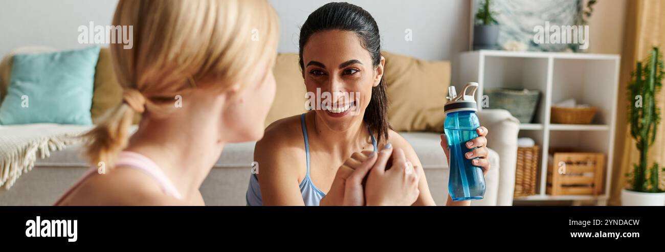 Zwei junge Frauen verbinden sich zutiefst und genießen einander Gesellschaft und ein erfrischendes Getränk. Stockfoto