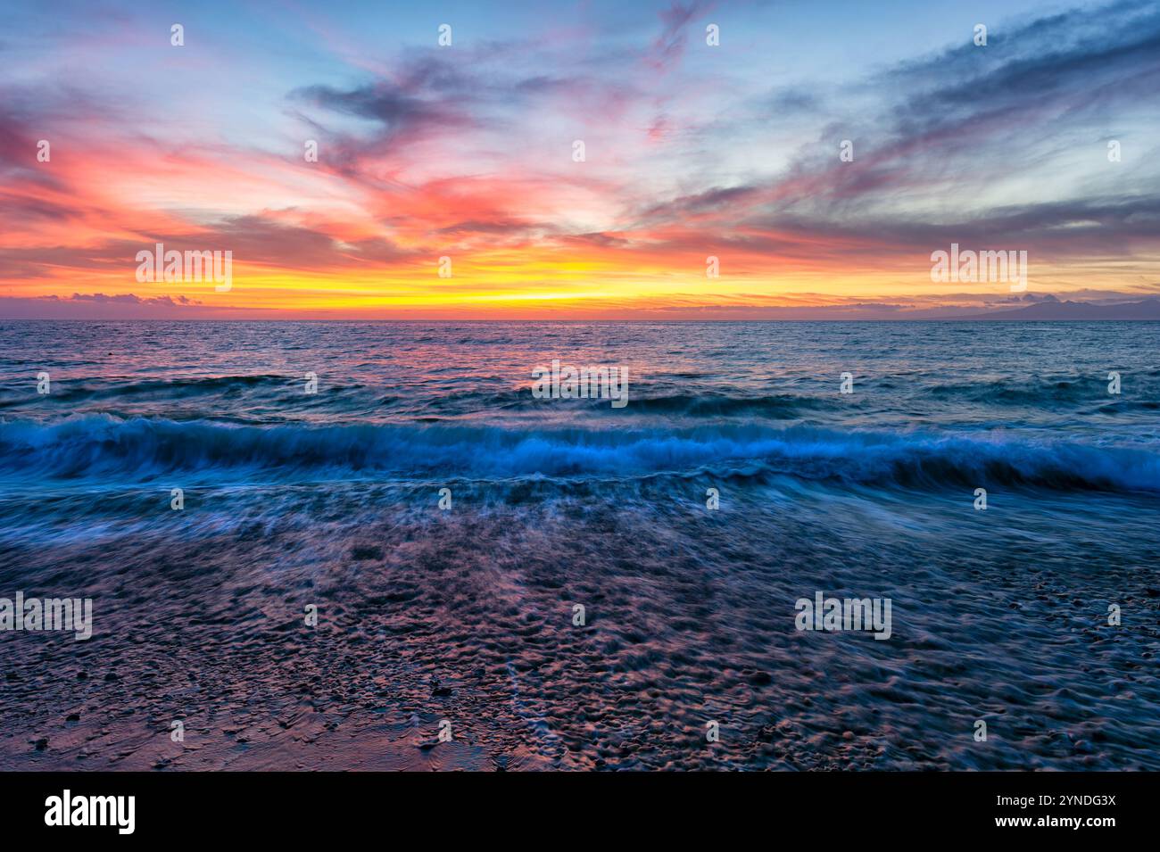 Eine Meereslandschaft Mit Goldenen Sonnenstrahlen, Die Durch Die Wolken Brechen Stockfoto