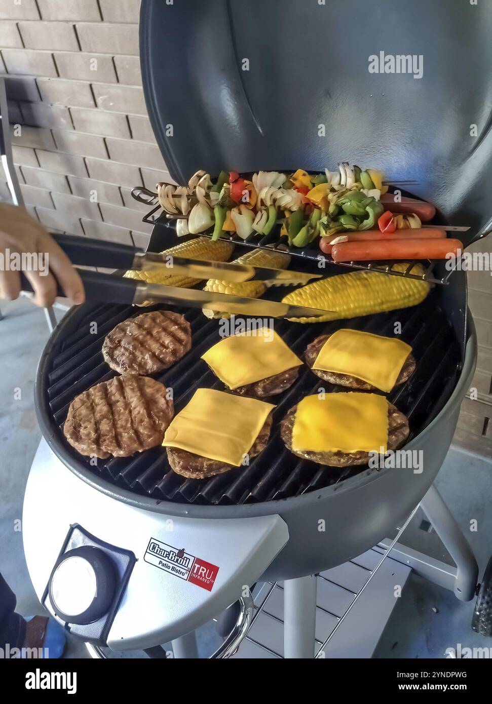 Calgary, Alberta, Kanada. Februar 2024. Eine Nahaufnahme auf dem offenen Deckel eines Graphite Patio Bistro Electric Barbecue mit köstlichen Speisen Stockfoto