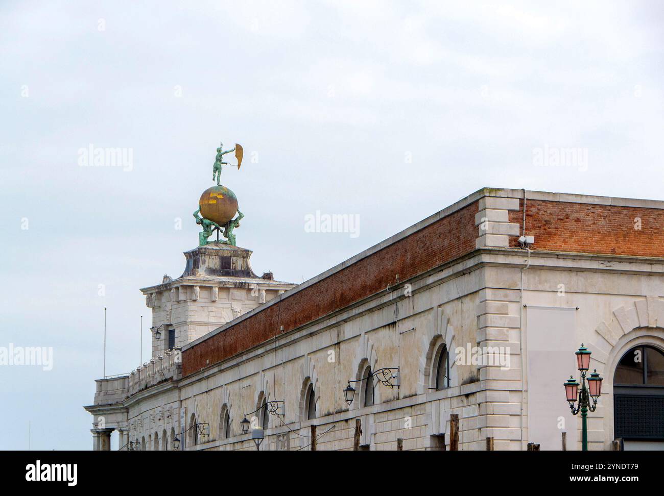 Dieses Foto zeigt das Gebäude Punta della Dogana in Venedig, Italien, mit der berühmten Glücksstatue auf einer goldenen Kugel. Die Histori Stockfoto