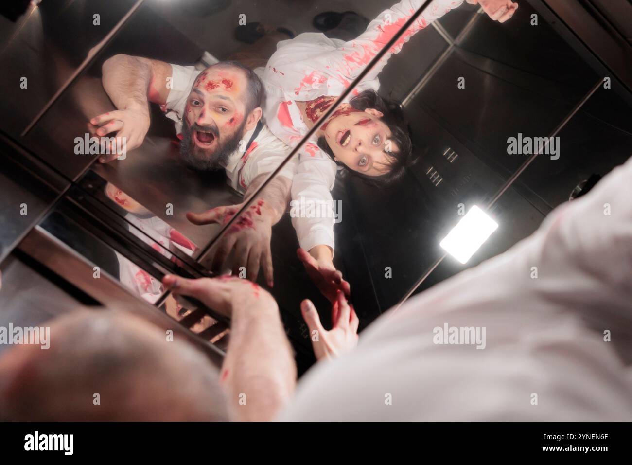 Schauspieler spielen finstere Zombiemonster in der Horrorfilmszene, sehen Reflexion im Aufzugspiegel. Mann und Frau mit übernatürlicher Dämonenrolle in der Thriller-Drehsequenz in der Rolltreppe Stockfoto