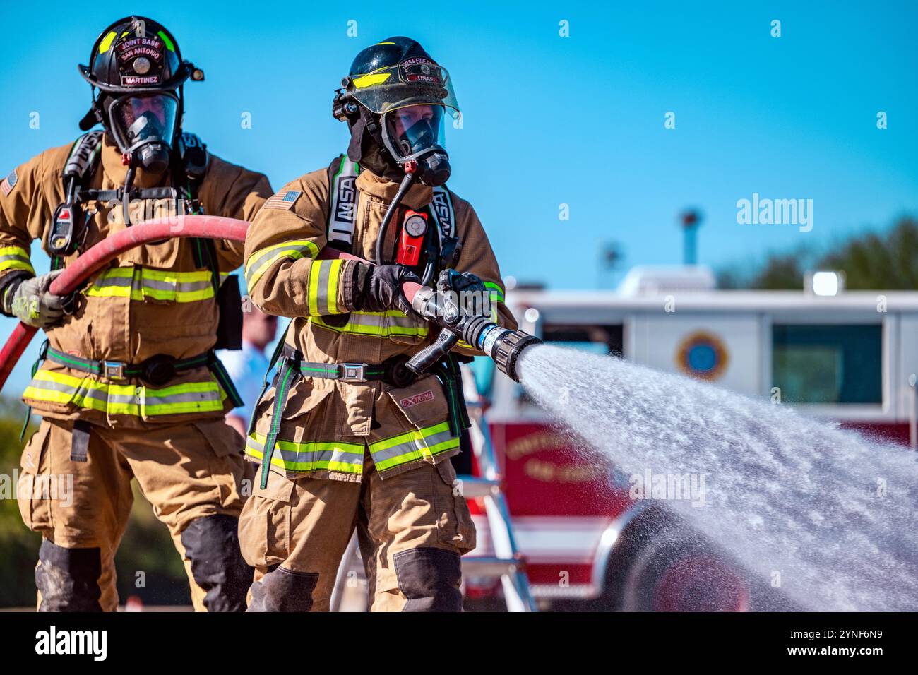 Die Feuerwehrleute der Joint Base San Antonio nehmen am 20. November 2024 an einer Live-Feuerübung in JBSA-Fort Sam Houston, Texas, Teil. Zweck der Schulung ist es, die Fähigkeit der Feuerwehr zu bewerten, einen Brand in einem Flugzeug zu löschen, während sie die Kontrolle über die Situation behält und ein Team leitet. Dies bereitet sie auf Notfälle in der Praxis vor. Während des Trainings wechselten die Mitglieder die Positionen im Trupp, um sicherzustellen, dass alle mit jeder Aufgabe vertraut waren. (Foto der U.S. Air Force von Taylor Curry) Stockfoto