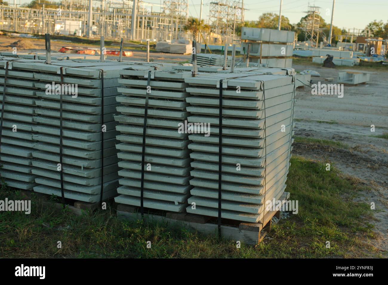 Weitsicht-Schlitten von vorgespannten Zementplanken in einem im Bau befindlichen elektrischen Umspannwerk. Hochleistungsleitungen in Florida. Blauer Himmel. Infrastruktur wird aktualisiert Stockfoto