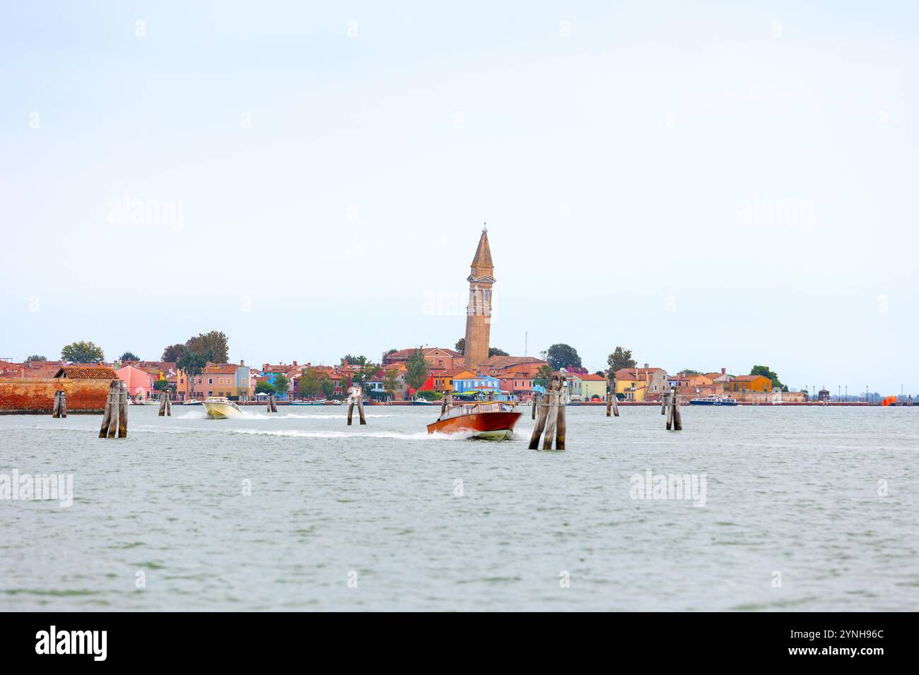 Insel Burano, Italien - 1. Oktober 2024: Bunte Häuserarchitektur, Blick vom Meer, Straße auf der berühmten Insel in der Nähe von Venedig. Reise- und Urlaubskonz Stockfoto