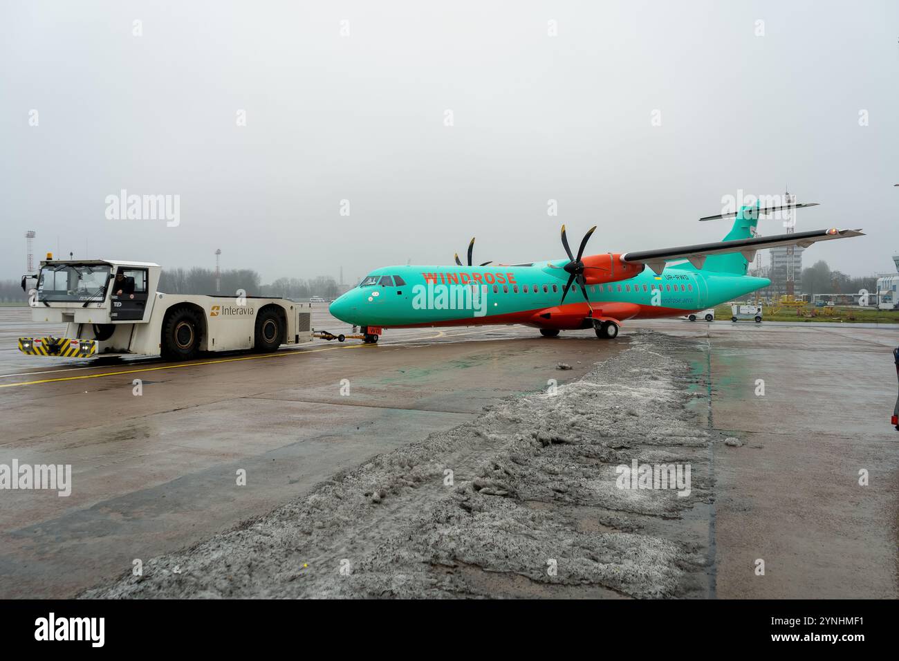 Abschleppen eines Flugzeugs auf einer starren Anhängevorrichtung zur Landebahn. ATR 72-600 Flugzeuge Ukrainische Windrose Fluggesellschaften. UR-RWD Ukraine, Kiew - 29. Dezember 2020 Stockfoto