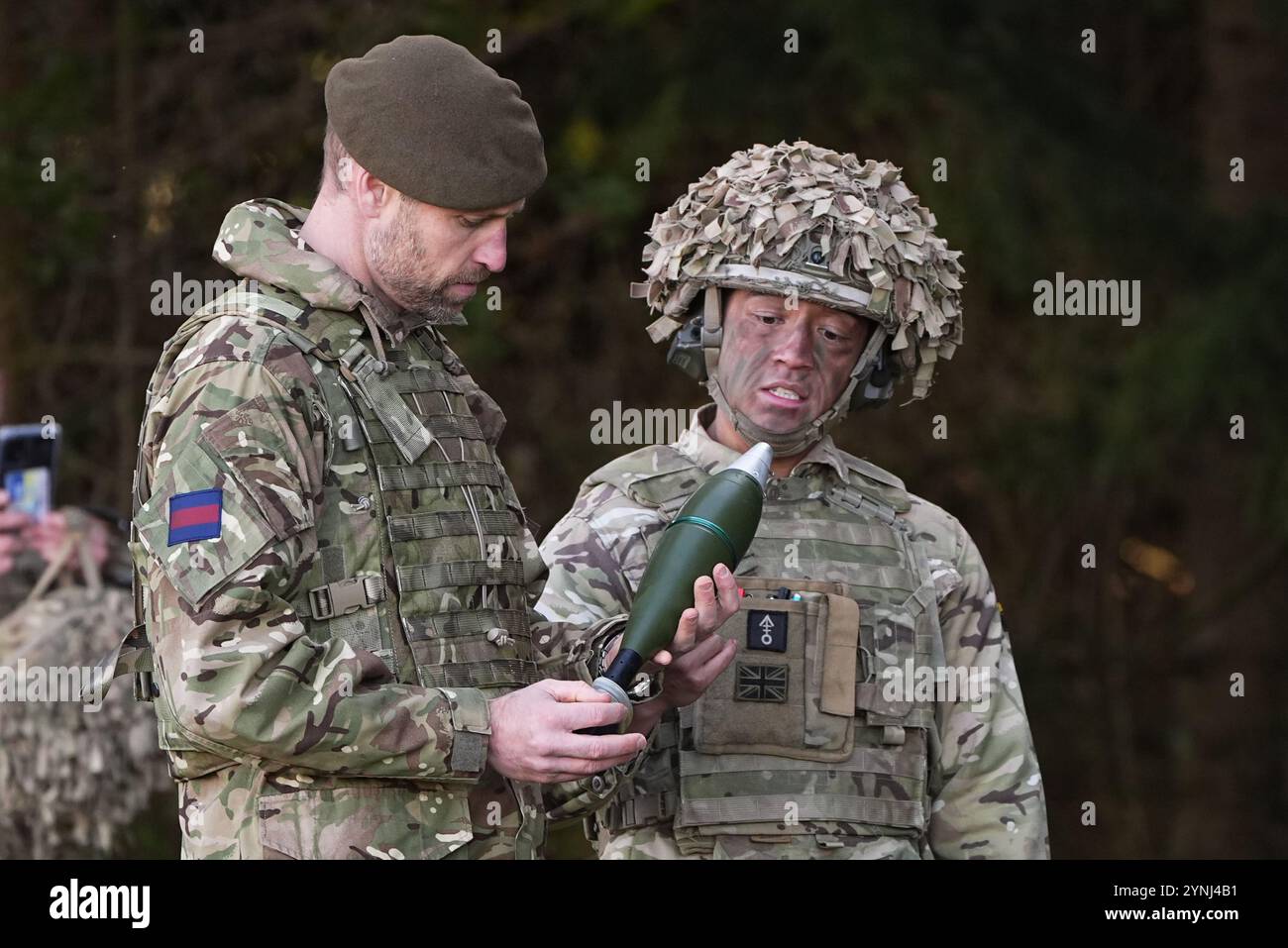 Der Prinz von Wales, Colonel der Walisischen Garde, (links), hält einen 81-mm-Mörser-Hochexplosionsring (HE) während eines Besuchs des 1. Bataillons der Walisischen Garde in Salisbury Plain, Wiltshire, um zu erfahren, wie sie vom Zeremonialdienst zurück zur Field Army übergegangen sind. Bilddatum: Dienstag, 26. November 2024. Stockfoto