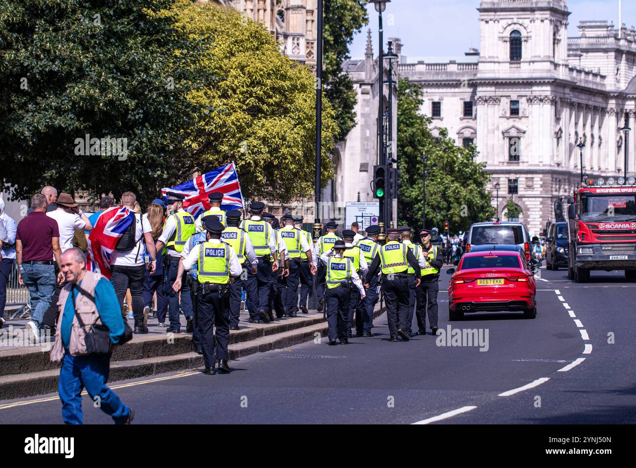 Eine kleine Gruppe von pro-britischen rechtsorientierten Demonstranten wird von der Metropolitan Police Force im Zentrum Londons streng überwacht Stockfoto