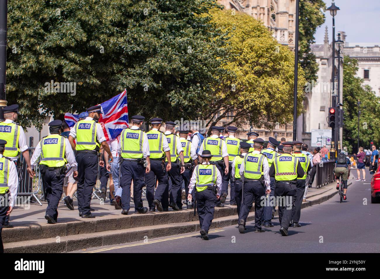 Eine kleine Gruppe von pro-britischen rechtsorientierten Demonstranten wird von der Metropolitan Police Force im Zentrum Londons streng überwacht Stockfoto