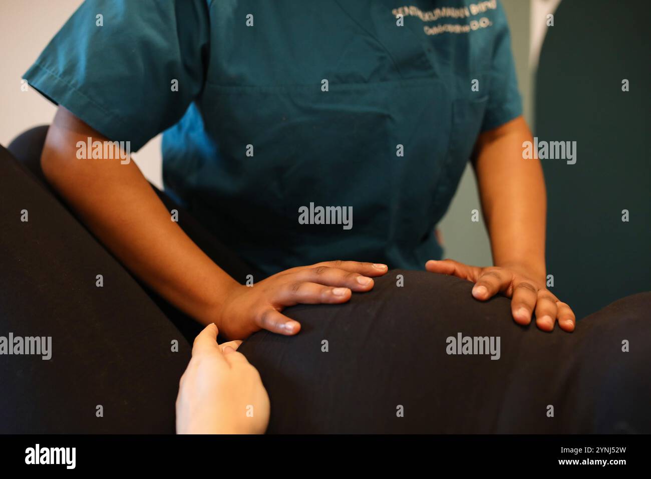 Jossigny, Ile De France, Frankreich. Februar 2023. Brindini Senthilkumaran, ein Osteopath in der Region Paris, führt einen dorsalen Säulentest an einer schwangeren Patientin durch. Ziel der Technik ist es, muskuläre und ligamentäre Spannungen im Gebärmutterbeutel zu lösen, wodurch Schmerzen in der Wirbelsäule der Mutter reduziert und die korrekte Positionierung des Babys und die Entwicklung der Gebärmutter zur Vorbereitung auf die Geburt gefördert werden. Brindini Senthilkumaran ist ein französischer Osteopath, der auf perinatale Pflege und Frauengesundheit spezialisiert ist. (Credit Image: © Apolline Guillerot-Malick/SOPA Images via ZUMA Press Wire) REDAKTIONELLE VERWENDUNG ONL Stockfoto