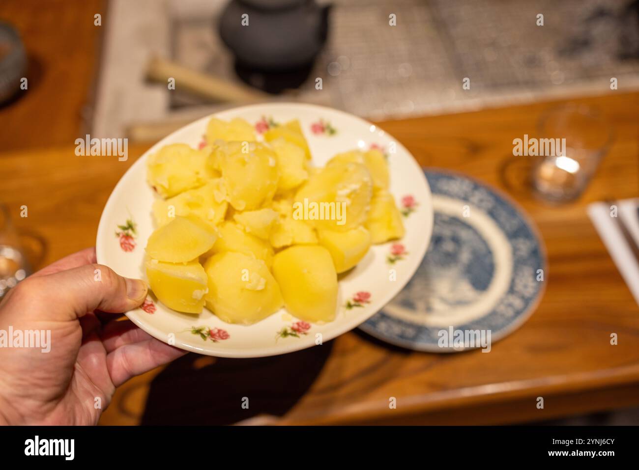 Gekochte gelbe Kartoffeln serviert auf einem Blumenteller – rustikales Hausmannskost Stockfoto