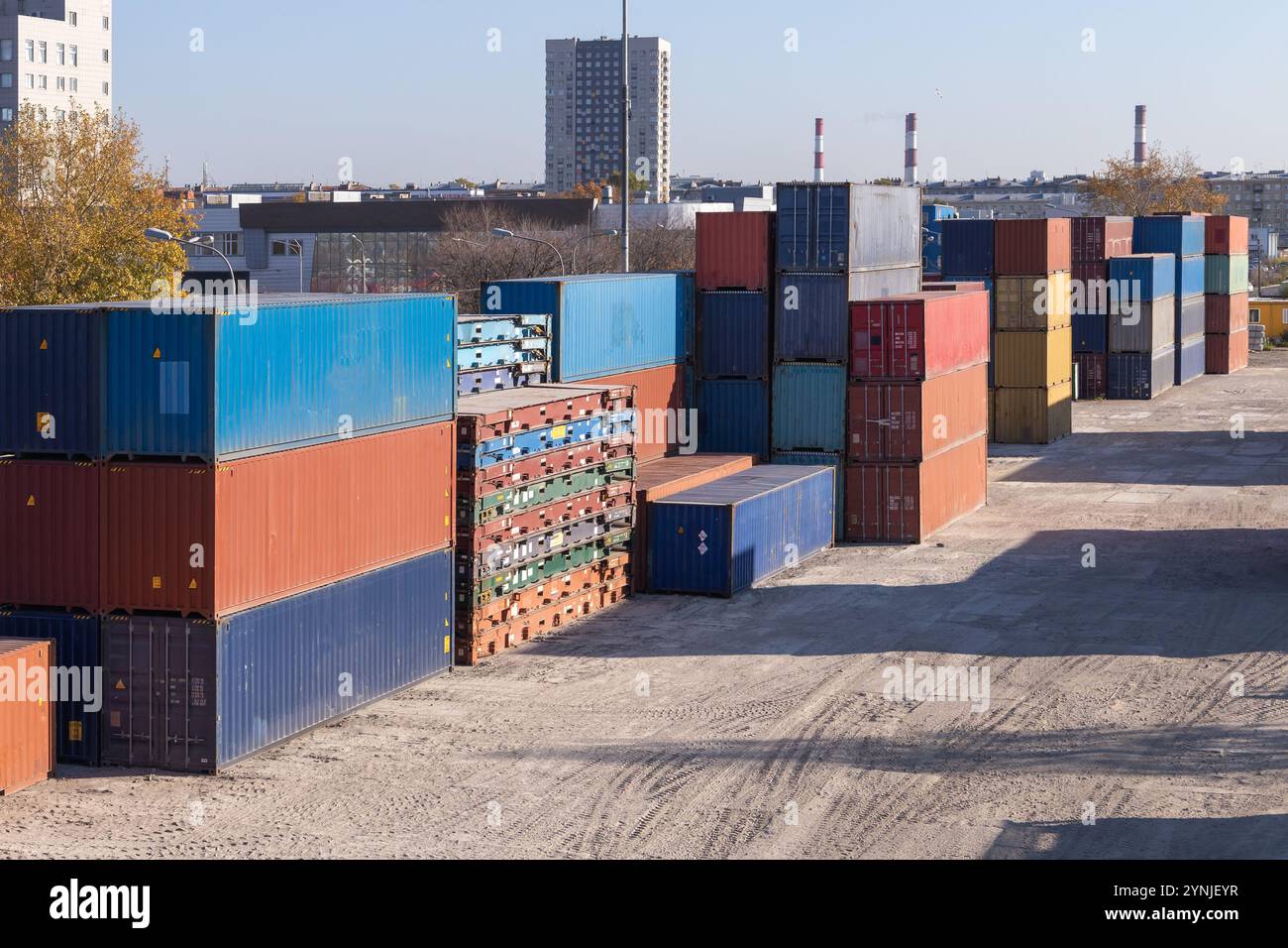 An einem sonnigen Tag stapeln sich bunte Frachtcontainer im Lagerbereich Stockfoto