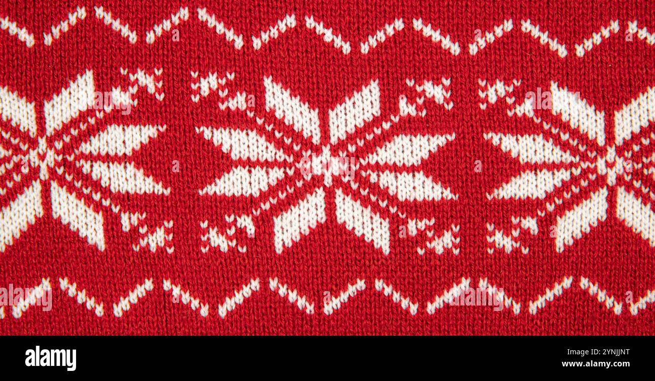 Weißer Pullover mit acht spitzen Sternen. Weiße Sterne auf rotem Hintergrund, Studio-Aufnahme, drinnen. Stockfoto