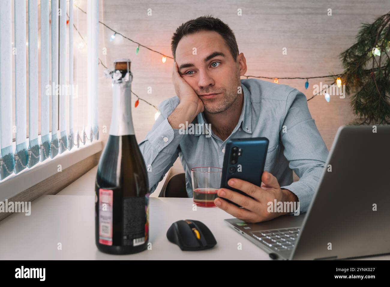 Junger Mann mit Kater nach der Neujahrsparty im Büro. Der Geschäftsmann ist bei der Arbeit müde. Ein betrunkener Mitarbeiter ist nach einer Firmenfeier krank Stockfoto