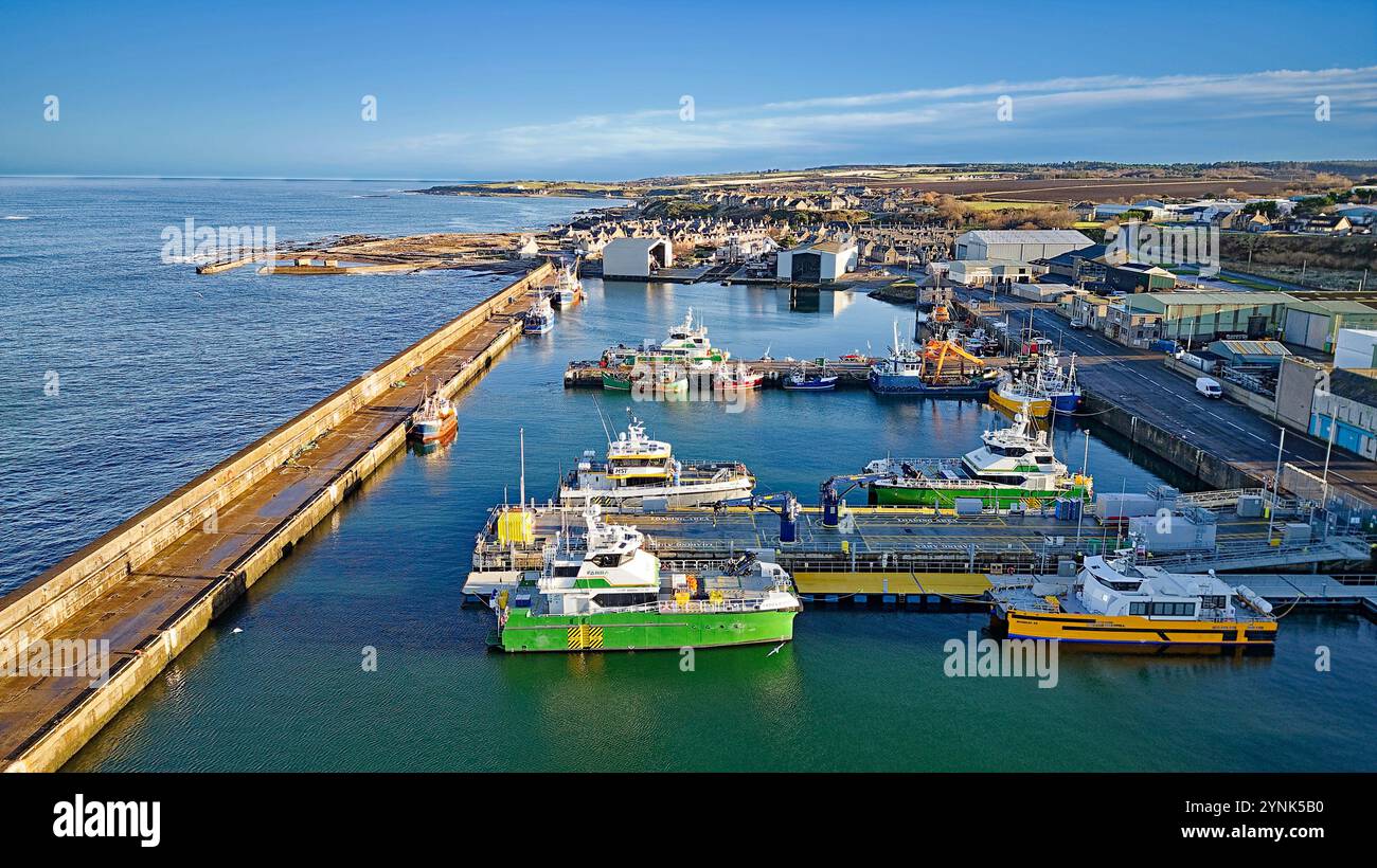 Buckie Harbour Moray Coast Schottland Blick über vertäute Offshore-Windkraftanlagen-Unterstützungsschiffe und Fischerboote zu den MacDuff-Werften Stockfoto