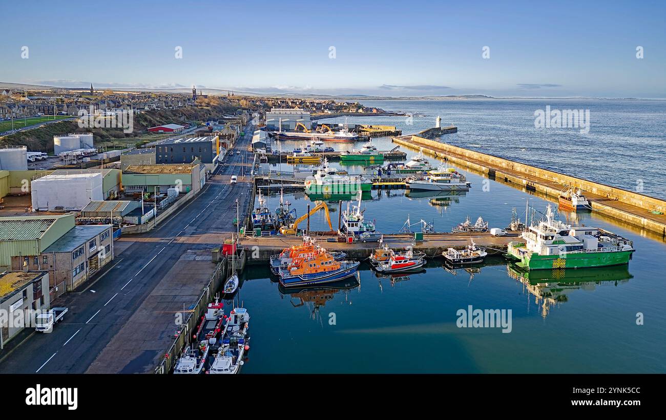 Buckie Harbour Moray Coast Schottland Blick über vertäute Offshore-Windkraftanlagen-Unterstützungsschiffe Rettungsboote Fischerboote und Commercial Road Stockfoto