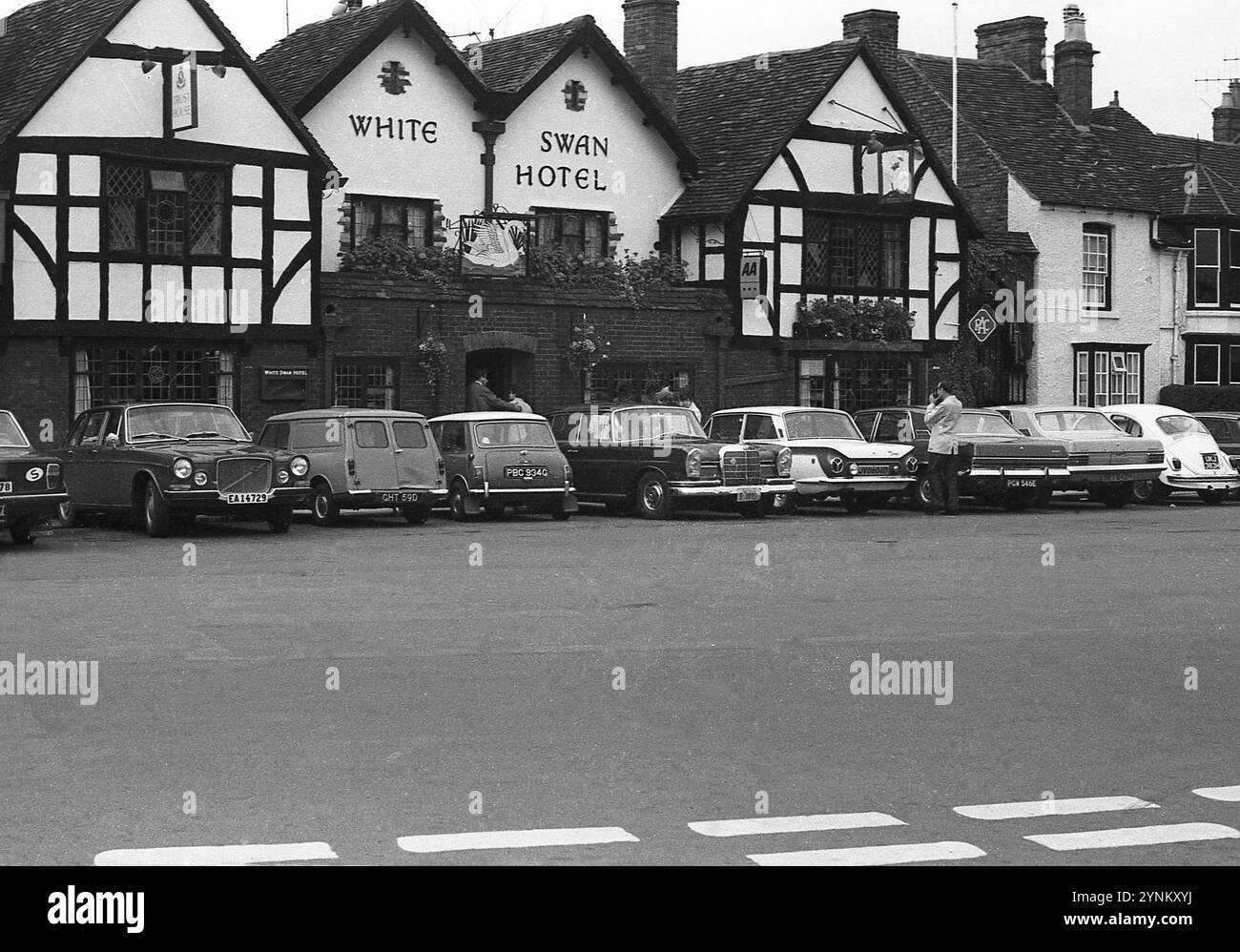 1970er Jahre, historische Autos aus der Zeit, die vor dem historischen alten Public House geparkt wurden, The White Swan Hotel, Rother Street, Stratford upon Avon, England, Großbritannien. Der Weiße Schwan existiert seit 1560. Stockfoto