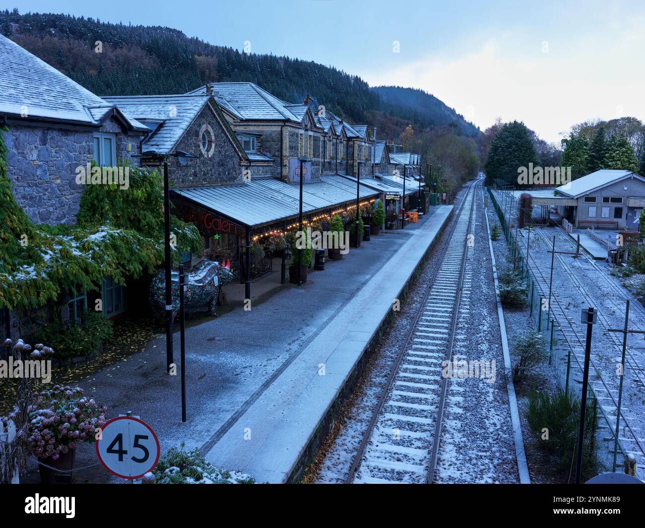 Am frühen Morgen an einem schneebedeckten Bahnhof im Touristendorf Betwys y Coed, Wales, an einem Wintertag. Stockfoto