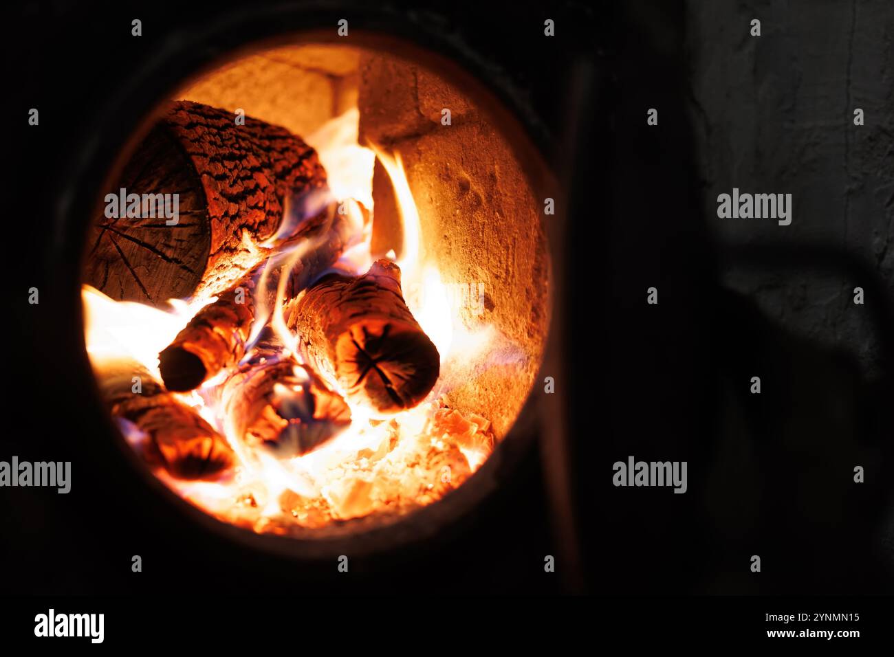 Nahaufnahme brennender Holzscheite in einem Ofen mit hellen Flammen und glühender Glut Stockfoto