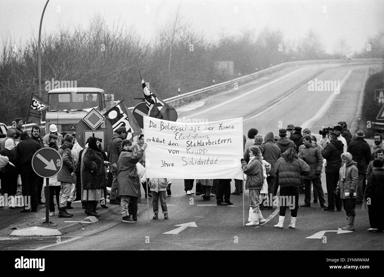 Teile der Belegschaft der Firma Elastoform erklärt den Stahlarbeitern von Krupp ihre Solidarität und blockiert am 10.12.1987 eine Autobahnauffahrt in Duisburg. Arbeitskampf in der Stahlindustrie *** Teile der Elastoform-Belegschaft erklären sich mit den Krupp-Stahlarbeitern solidarisch und blockieren am 10. Dezember 1987 eine Autobahnrampe in Duisburg Stockfoto