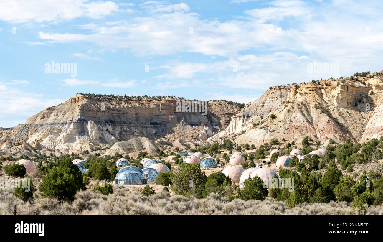 Einzigartige Kuppelstrukturen, die sich unter einem großen Wüstenkliff in der abgelegenen südwestlichen Landschaft von Utah, USA, gruppieren Stockfoto