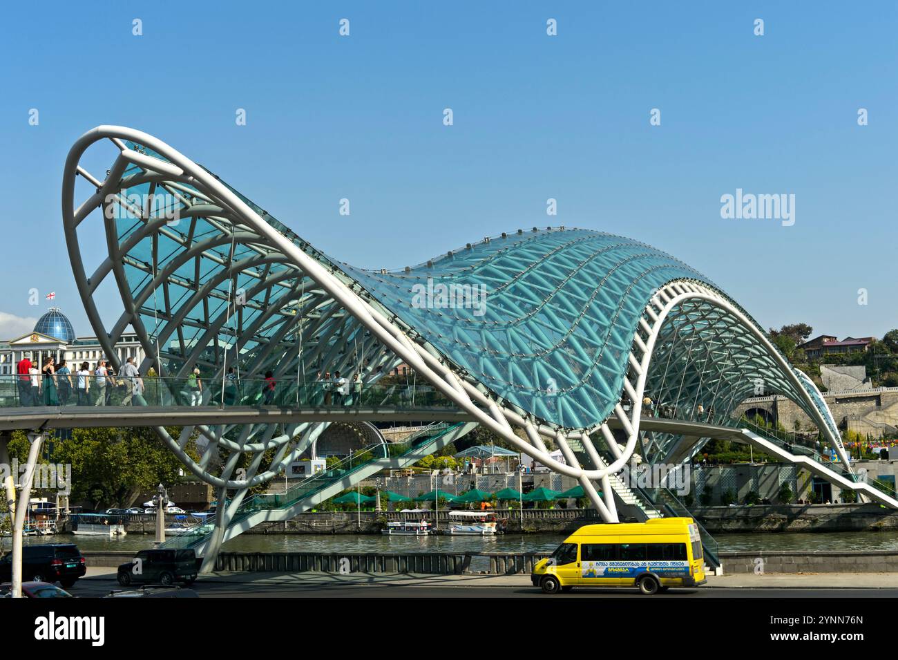 Die futuristische, bogenförmige Friedensbrücke über den Fluss Kura in Tiflis, Georgien Stockfoto