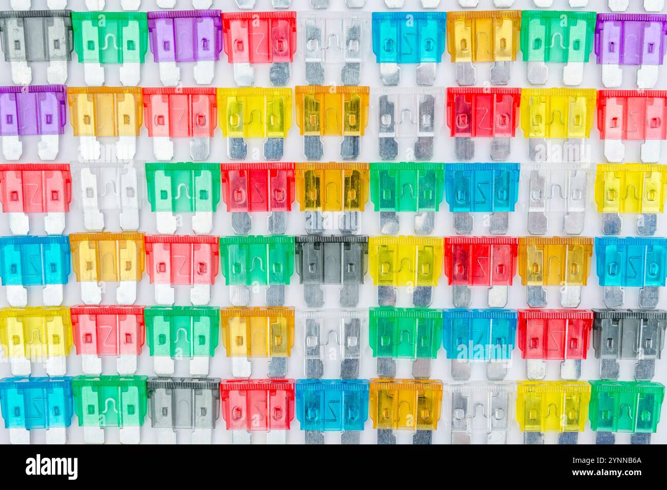 Übersichtlich angeordnete Masse an bunten Kfz-Stecksicherungen in verschiedenen Amp-Farbcodierung. Metapher-Diversität, Wahl. Stockfoto