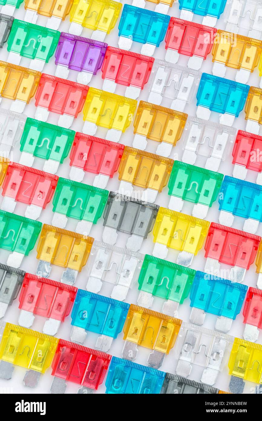 Übersichtlich angeordnete Masse an bunten Kfz-Stecksicherungen in verschiedenen Amp-Farbcodierung. Metapher-Diversität, Wahl. Stockfoto