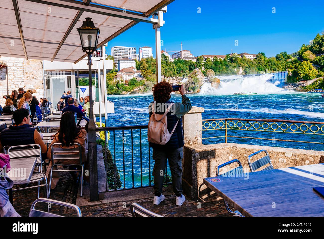 Cafe-Terrasse am Schloss Wörth vor den Wasserfällen. Der Rheinfall ist ein Wasserfall in der Schweiz und der mächtigste Wasserfall in Europa Stockfoto
