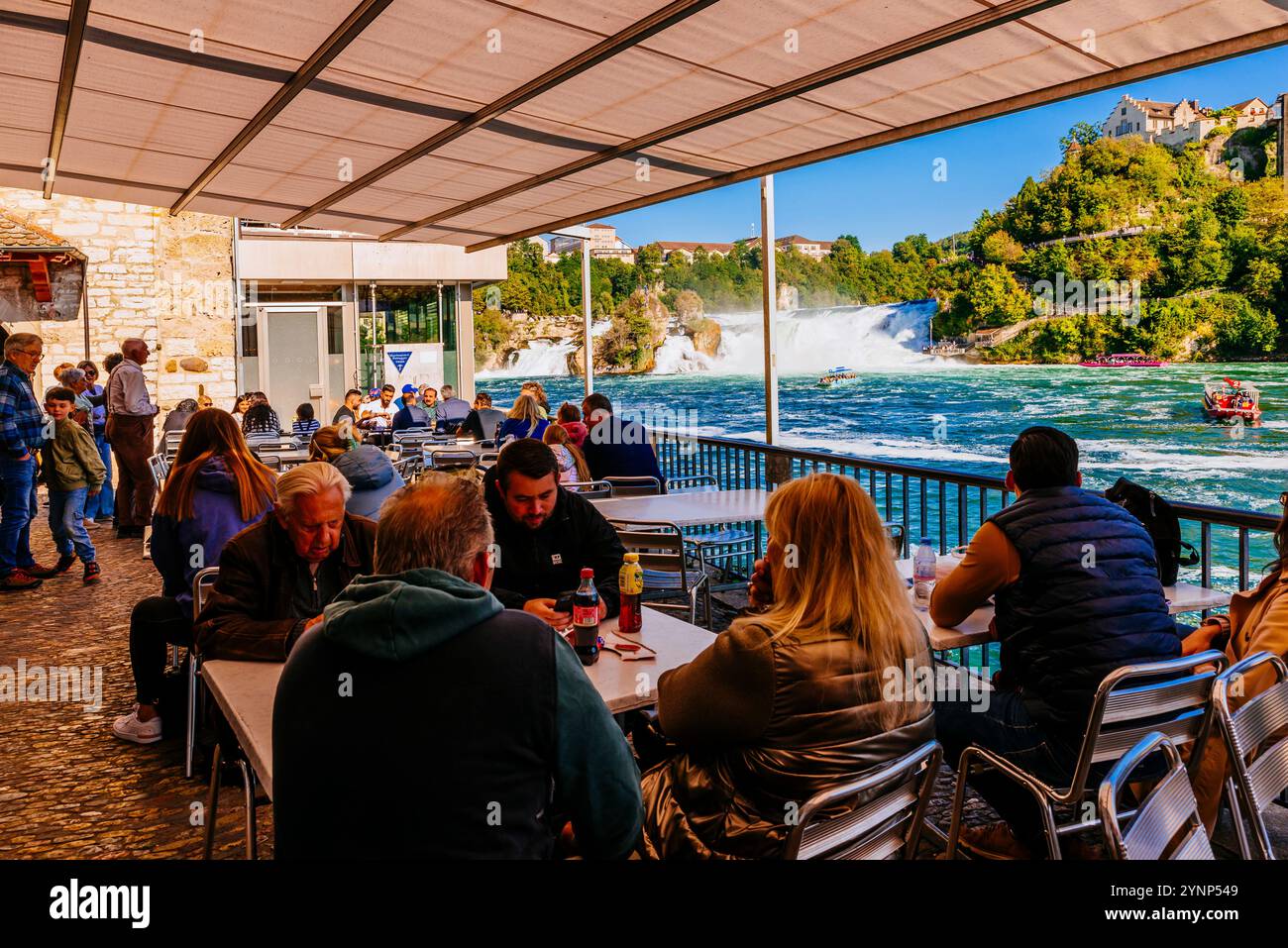 Cafe-Terrasse am Schloss Wörth vor den Wasserfällen. Der Rheinfall ist ein Wasserfall in der Schweiz und der mächtigste Wasserfall in Europa Stockfoto
