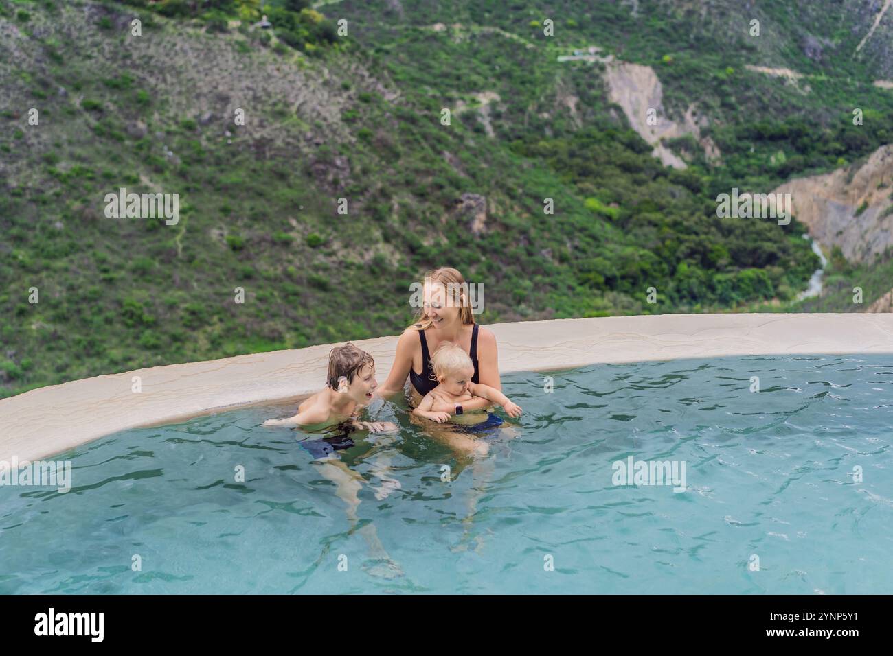 Mutter mit ihrem Kleinkind und ihren Söhnen im Teenageralter baden in den heißen Quellen von Grutas Tolantongo, Mexiko. Familienabenteuer, Entspannung und natürliches Wellness Stockfoto