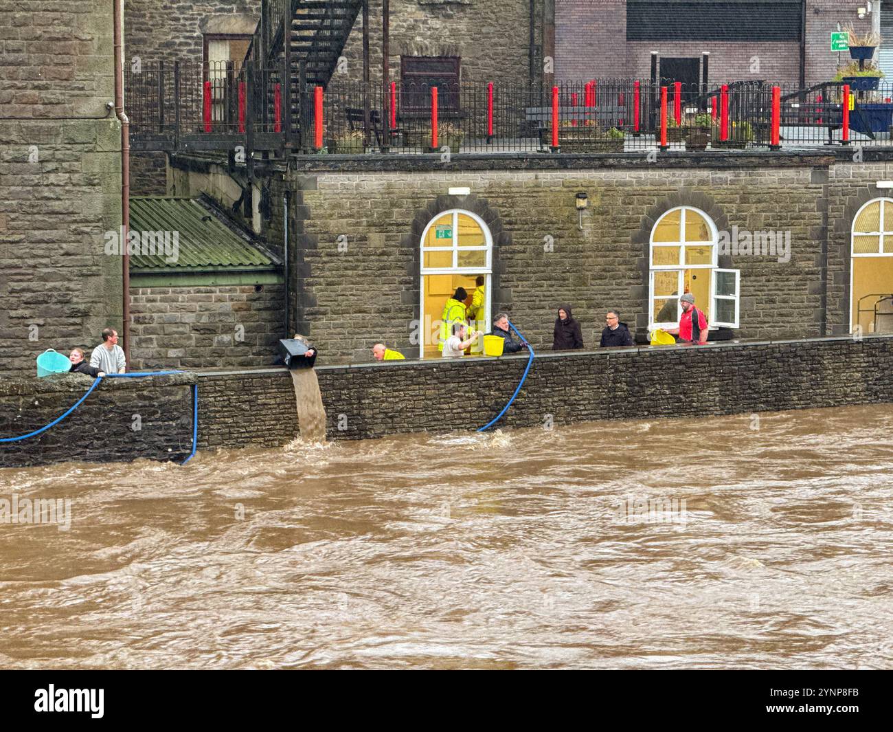 Pontypridd, Wales, Großbritannien - 24. November 2024: Freiwillige verwenden Eimer und Abfalleimer, um Wasser aus dem Keller des Stadtmuseums zu holen Stockfoto