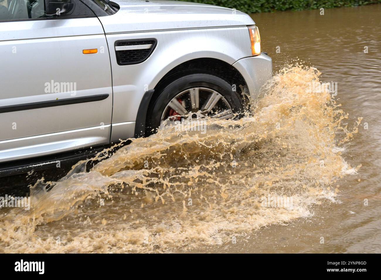 Treforest Industrial Estate, Wales, Großbritannien - 24. November 2024: Auto fährt durch Hochwasser nach starkem Regen durch Sturm Bert Stockfoto