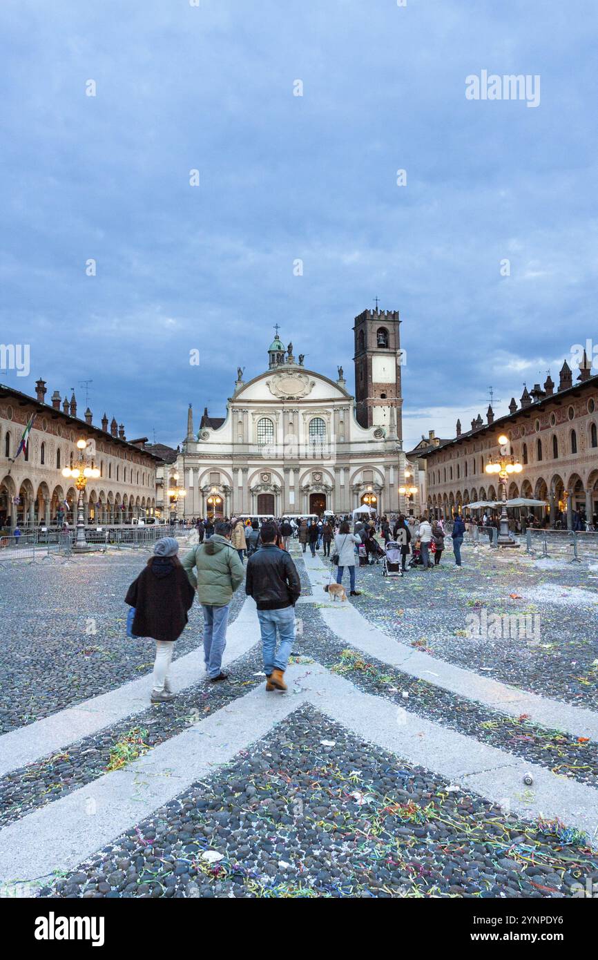 Der mit Konfetti übersäte Platz vor einem reich verzierten historischen Gebäude fängt die festlichen Nachwirkungen einer gefeierten Veranstaltung ein. Vigevano, Lombardei. Italien Stockfoto
