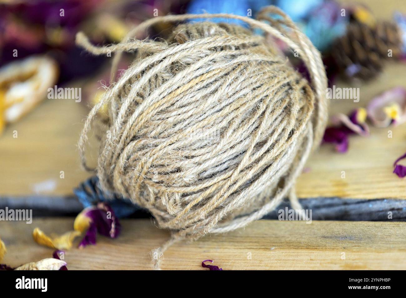 Close-up-Rolle aus braunem Jutegarn zum Basteln auf Holztisch liegend. Thema Hobbys und Bastelmaterialien Stockfoto