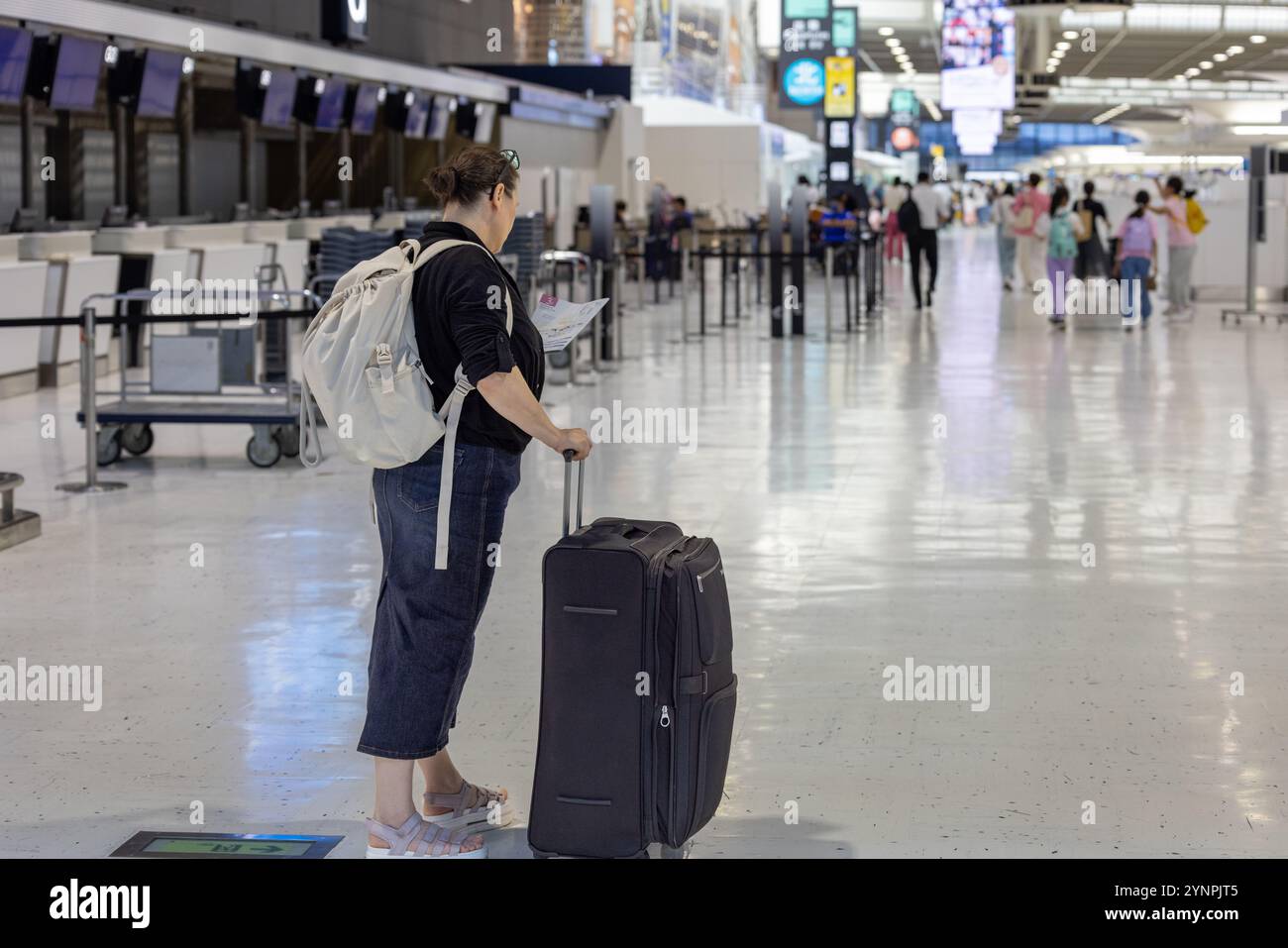 Reisende im Flughafenterminal mit Gepäck, Dokumente vor Abflug prüfen Stockfoto