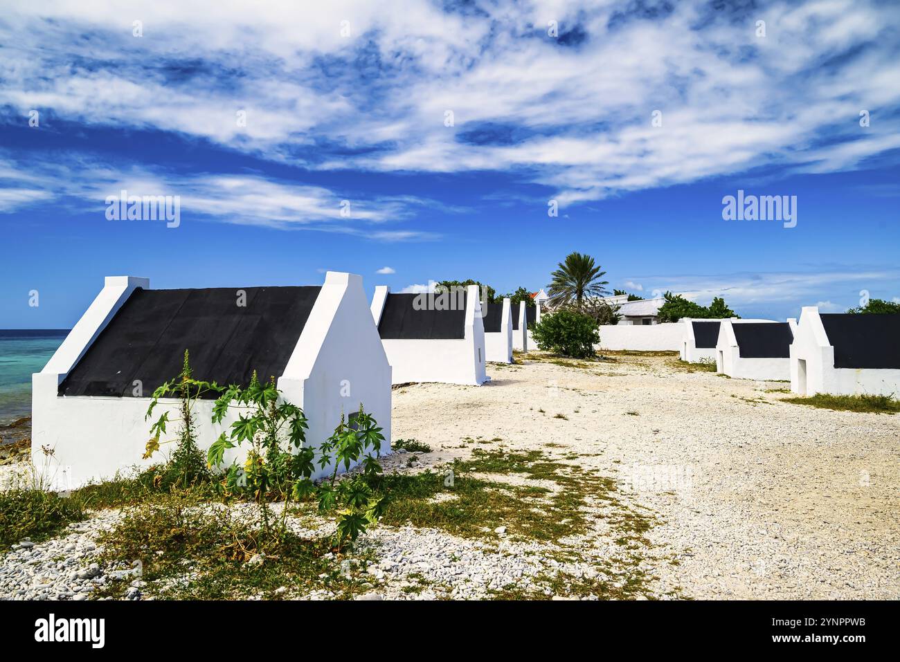 Ein Blick auf die Sklavenhäuser auf Bonaire in der Karibik mit blauem Himmel und türkisfarbenem Meer Stockfoto