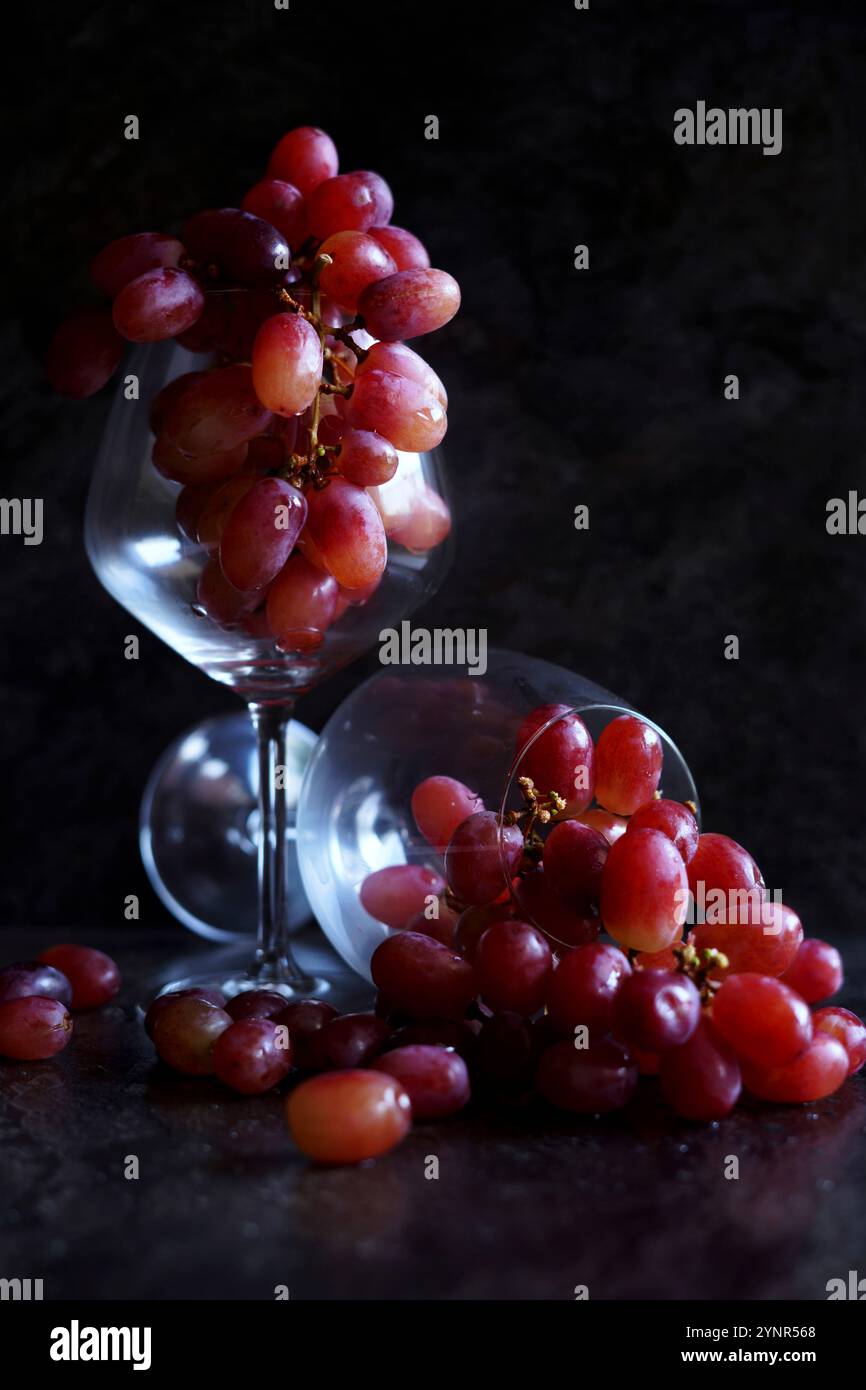 Rote Trauben in Weingläsern. Stillleben auf dunklem Hintergrund. Stockfoto