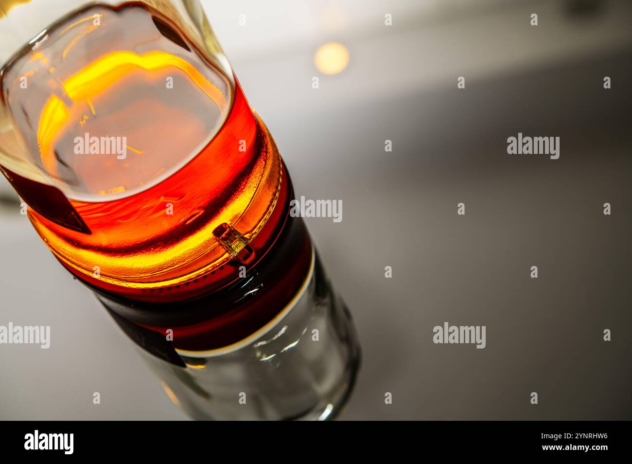 Nahaufnahme einer Whiskey-Flasche mit bernsteinfarbenem Farbton und luxuriösem Design, perfekt für die Werbung für Spirituosen, Cocktails, Verkostungen und Upscal Stockfoto